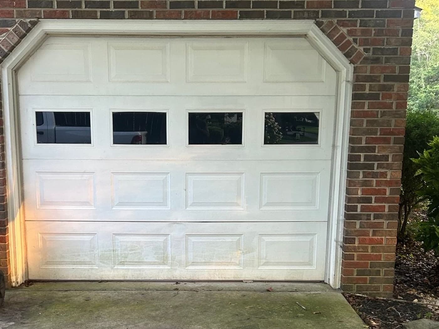 Existing white raised-panel garage door on a North Alabama brick home